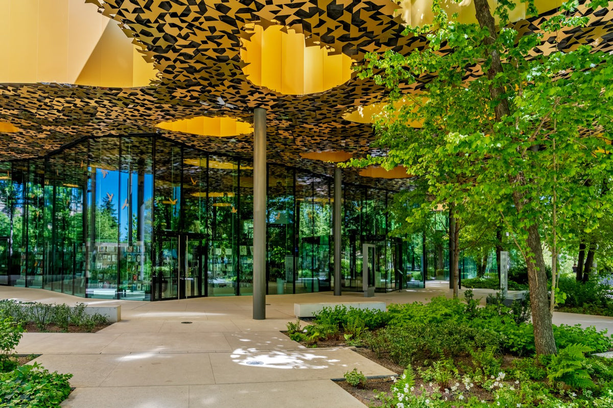 House of Music Hungary seen through its glass walls under the perforated golden canopy