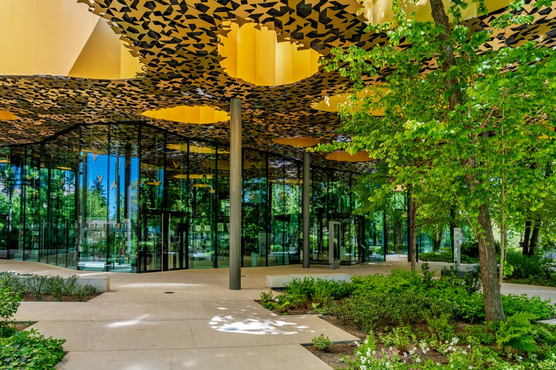 House of Music Hungary seen through its glass walls under the perforated golden canopy