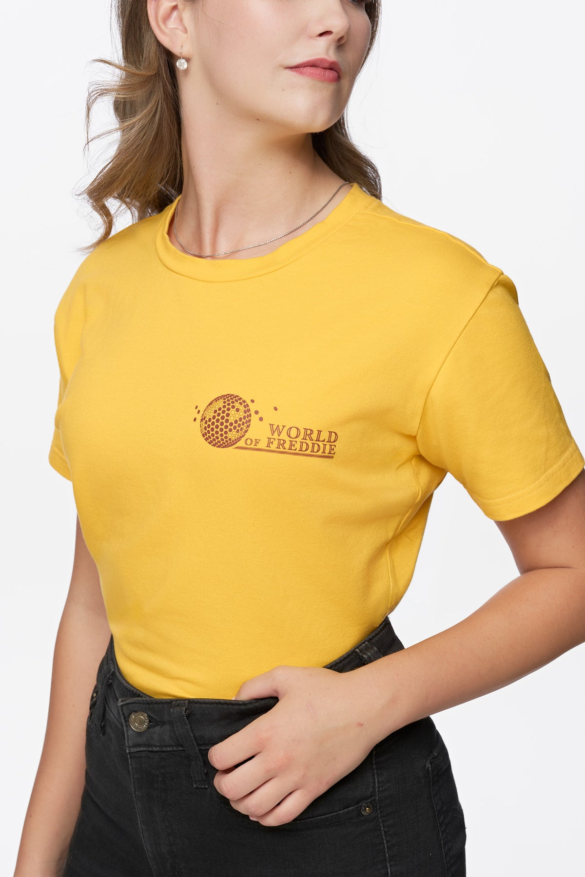 Primer plano del logotipo de World of Freddie en el pecho de la camiseta amarilla