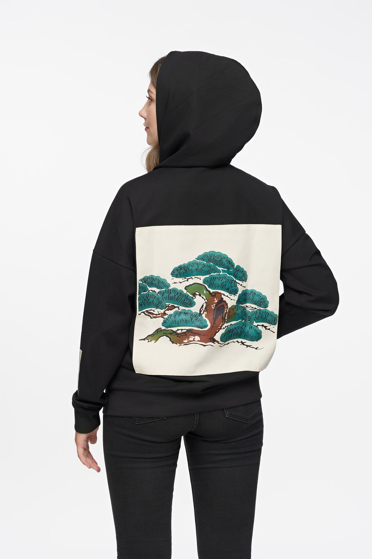 Woman wearing the Tree Edition Hoodie with the hood up